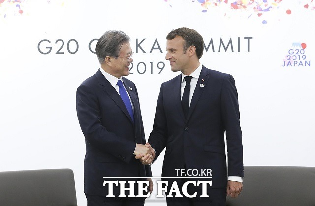 문재인 대통령이 18일 사회관계망서비스(SNS)를 통해 코로나19 확진 판정을 받은 에마뉘엘 마크롱(오른쪽) 프라스 대통령의 쾌유를 빌었다. 지난해 6월 일본 오사카에서 열린 한·프랑스 정상회담에서 악수하는 양 정상. /청와대 제공