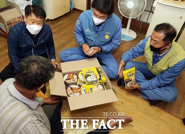 포항제철소 임직원들이 해도동 등 인근 자매마을의 독거노인 가정을 방문해 식료품을 전하고 어르신들의 안부를 묻고 있는 모습/포항제철소 제공