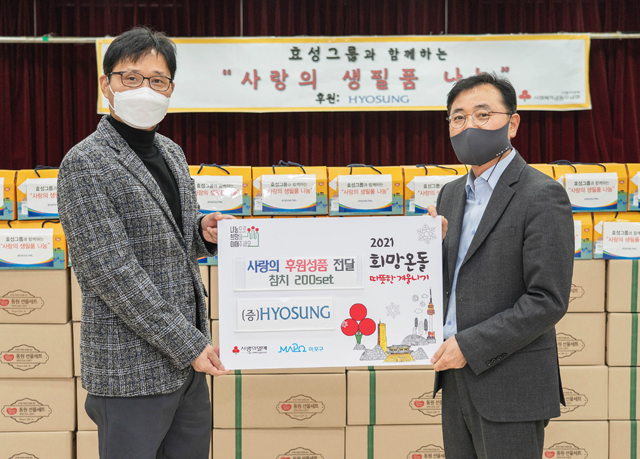 김건탁 아현동장(왼쪽)과 효성 커뮤니케이션실 최형식 상무가 서울 마포구 아현동 취약계층을 위한 생필품 전달식을 진행하고, 기념 사진을 찍고 있다. /효성 제공