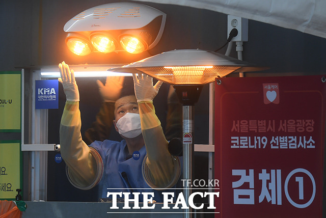 코로나19 확진자가 이틀째 1000명대를 기록한 30일 오전 서울 중구 서울광장 선별진료소에서 의료진이 난로를 이용해 추위를 녹이고 있다. /이동률 기자