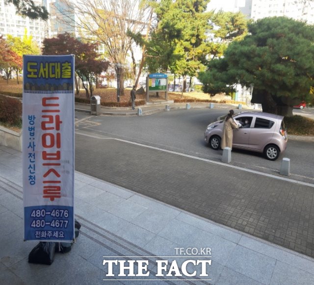 구미시는 6일 코로나19 확산으로 공공기관이 임시휴관에 들어감에 따라 산하 모든 도서관에서 비대면 도서대출 ‘드라이브-워킹 스루’를 운영하고 있다고 밝혔다. 도서관 직원이 차에 탄 시민에게 책을 건네고 있다/구미시 제공