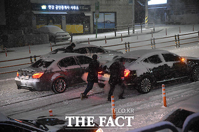 수도권 전역에 대설주의보가 발효된 6일 오후 서울 서초구 방배동 인근에서 운전자들이 눈길에 미끄러지는 차량을 밀고 있다. /이효균 기자