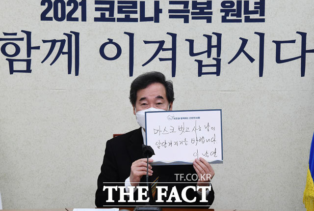 이낙연 더불어민주당 대표가 7일 오전 서울 여의도 국회에서 문재인 대통령의 신년인사회에 화상으로 참석해 마스크 벗고 사는 날이 앞당겨지기를 바랍니다라고 적힌 손 팻말을 들고 기념촬영을 하고 있다. /국회=남윤호 기자