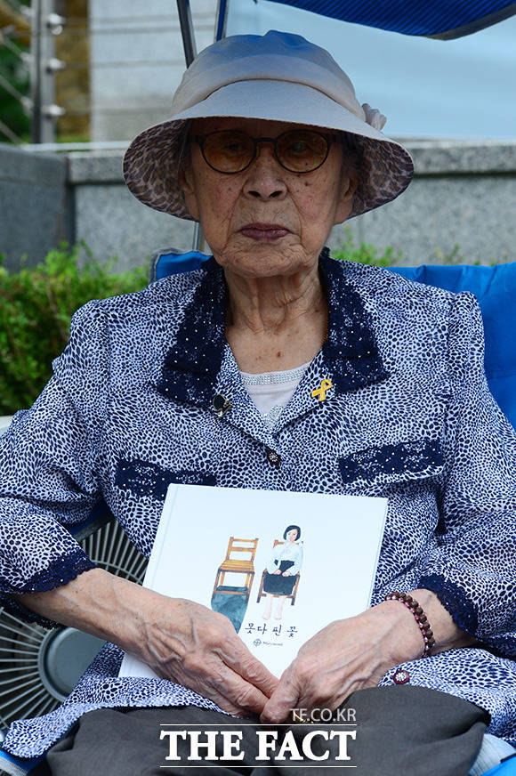 생전 김복동 할머니의 모습 제1296차 수요집회에 참석한 김복동 할머니가 한 참석자로부터 선물 받은 못다 핀 꽃 책을 들고 있다. /남용희 기자