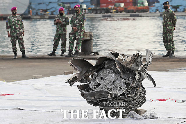 자카르타 탄중프리오크 항구에서 해병대원들이 자바섬 앞바다에서 추락 후 회수된 스리위자야 항공 SJ-182편의 파편을 바라보고 있다