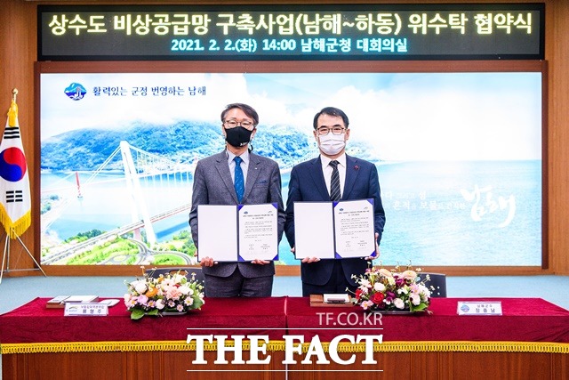 장충남(오른쪽)남해군수가 지방상수도 비상공급망 구축(남해~하동) 사업 위·수탁 협약식 기념촬영을 하고 있다./남해군 제공