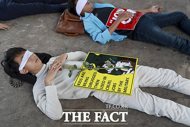 16일 미얀마 양곤에서 군사 쿠데타 반대 시위대가 눈을 가린 채 바닥에 누워 군정 아래 그들의 삶은 죽은 것이나 다름없다는 것을 표현하고 있다. /양곤=AP.뉴시스