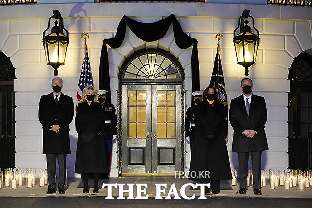 조 바이든 대통령과 질 바이든 여사, 카멀라 해리스 부통령, 세컨드젠틀맨 더그 엠호프(왼쪽부터)가 22일 워싱턴 백악관에서 코로나19로 사망한 50만명의 미국인을 기리며 촛불 추모식에 참여하고 있다. /워싱턴=AP.뉴시스