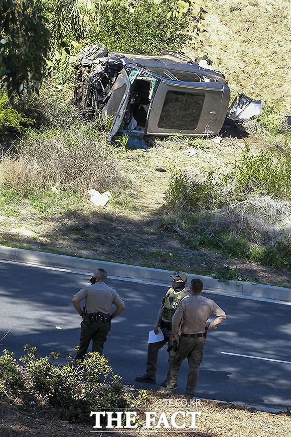 23일 로스앤젤레스 교외 란초 팔로스 베르데스의 한 도로 인근 타이거 우즈의 사고 차량이 파손된 채 전복돼 있다.