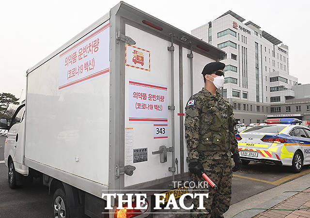 군사경찰이 백신 수송차량을 지키고 서 있다.