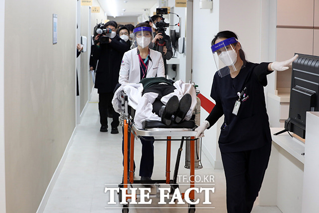 서울 소방이 신종 코로나바이러스 감염증(코로나19) 백신 접종 지원에 나선다. 9일 서울 중구 국립중앙의료원 중앙예방접종센터에서 진행된 코로나19 백신 접종 모의훈련에서 의료진들이 백신 접종 후 이상증세를 보인 참가자를 구급차로 이송하고 있다. /사진공동취재단