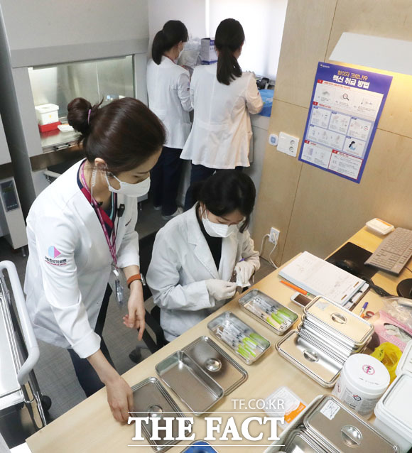 화이자의 코로나19 백신 접종이 시작된 27일 오전 서울 중구 국립중앙의료원 중앙예방접종센터에서 의료진이 소분한 코로나19 화이자 백신을 옮겨 담고 있다./사진공동취재단