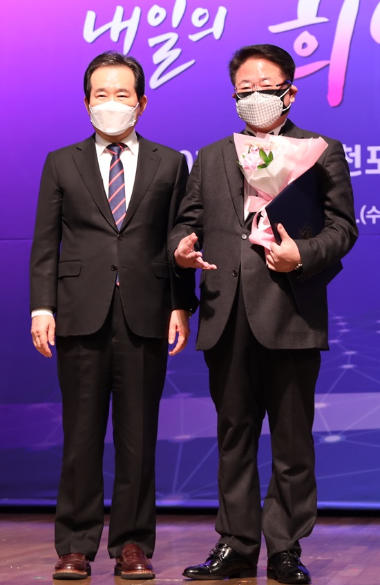 조정현(사진 오른쪽)은 3일 오후 서울 중구 대한상공회의소에서 열린 제10기 국민추천포상 수여식에서 정세균 국무총리로부터 직접 훈장을 받았다. /정현웨딩 제공