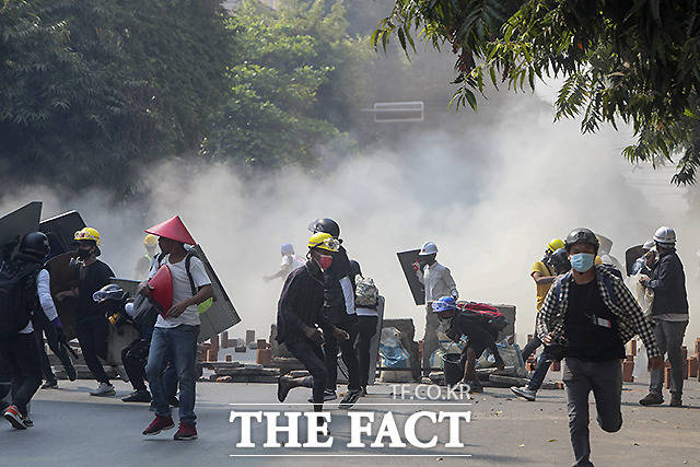 만달레이에서 군부 쿠데타 반대 시위대가 임시 구조물을 방패 삼아 경찰이 발사한 최루탄에 맞서고 있다.