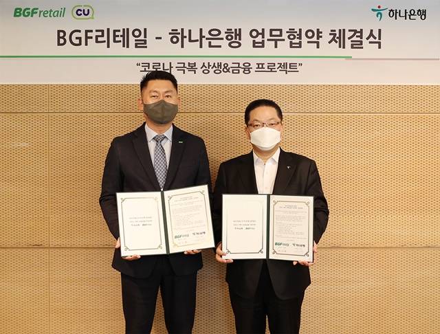 이호성 하나은행 중앙영업그룹 총괄부행장(오른쪽)과 안기성 BGF리테일 영업·개발부문장이 BGF리테일 사옥에서 상생 금융 업무협약을 체결하고 기념촬영을 하고 있다. /하나은행 제공