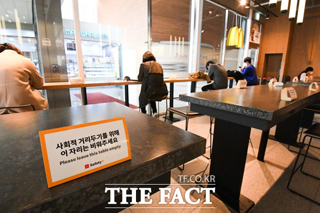 정부가 현행 거리두기 단계를 2주 더 연장한 12일 오후 서울 마포구 상암동 일대 음식점에서 점심시간을 맞은 직장인들이 거리두기를 지키며 식사를 하고 있는 가운데 거리두기 안내문이 설치되어 있다. /임세준 기자