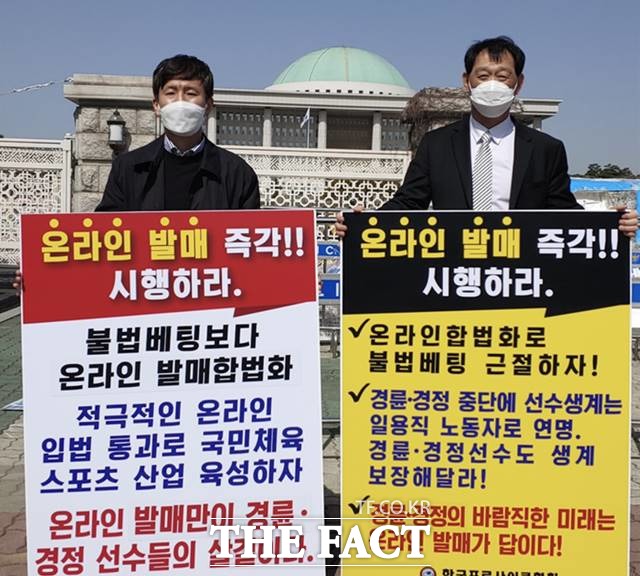 박상현 한국경정선수회장(왼쪽)과 박종현 한국프로사이클협회장이 경륜경정 온라인 발매를 촉구하는 1인 시위를 국회 앞에서 하고 있다./기금조성총괄본부 제공