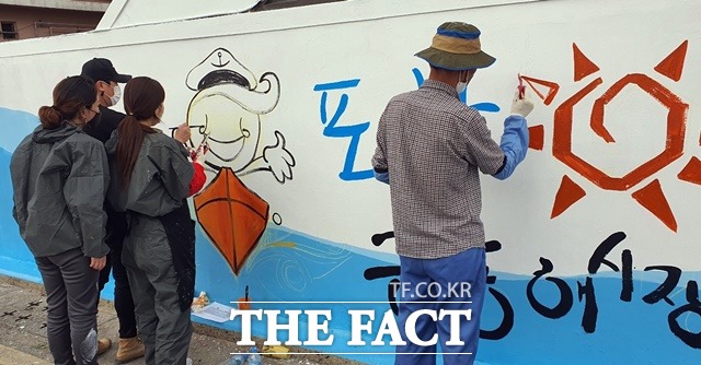 27일 해도동 큰동해시장에서 포항제철소 벽화봉사단이 벽화를 그리고 있다./포항제철소 제공