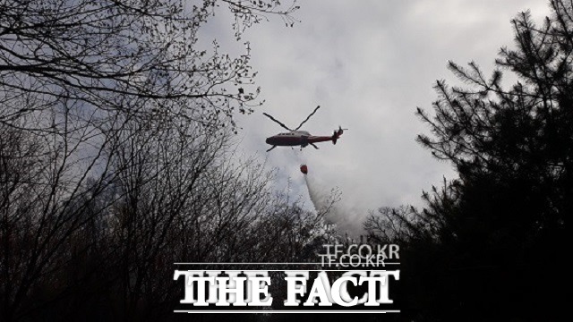 2일 오후 2시20분쯤 충북 청주시 용정동 3차 국도대체 우회도로 2공구 터널공사현장에서 발행한 불이 인근 김수녕양궁장 옆산으로 옮겨 붙어 소방헬기가 진화를 하고 있다. / 청주=김영재 기자