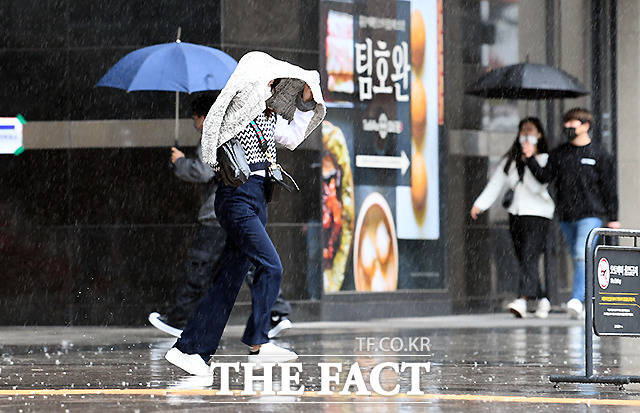 봄비가 내리는 3일 오전 서울 용산역 앞 광장에서 한 시민이 겉옷으로 비를 피하며 이동하고 있다. /이새롬 기자