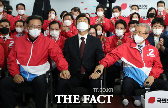 오세훈 국민의힘 서울시장 후보와 김종인 국민의힘 비상대책위원장, 정진석 의원이 7일 오후 서울 여의도 국민의힘 중앙당사에 마련된 개표상황실에서 4·7재보선 출구조사 결과를 바라보며 손을 잡고 있다. /남윤호 기자