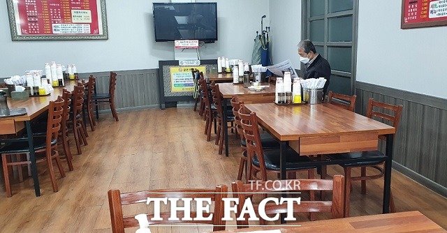 사회적 거리두기 2단계로 격상된 15일 오전 충북 괴산의 한 식당에 손님 한 명이 주문한 음식을 기다리며 손님이 무심히 신문을 보고 있다. / 괴산= 장동열 기자