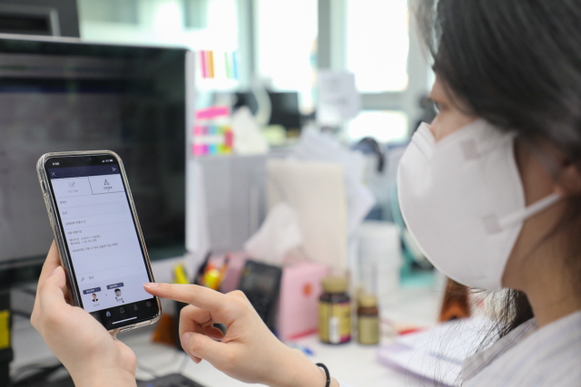 현대백화점은 사내 캠페인 등을 통해 보고 문화 개선에 직원들의 참여를 독려해 나갈 예정이다. 사진은 현대백화점에 근무하는 MZ세대 직원이 간편 보고 시스템을 사용하고 있는 모습. /현대백화점 제공