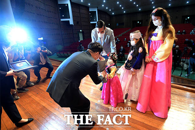 국적증서 수여를 위해 무대에 오른 토프락웨이스 가족과, 가족에게 꽃다발 받는 박 장관