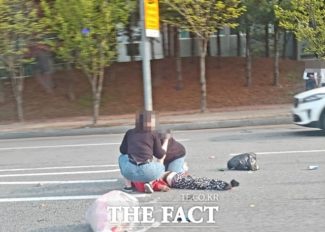 무단횡단을 하던 할머니가 차에 치여 쓰러지자 시민들이 심폐소생술을 하고 있다. / 독자제공