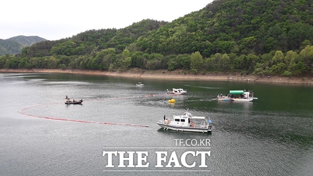 23일 오후 4시20분쯤 사고헬기가 예인선에 이끌려 크레인이 설치된 문의대교로 옮겨지고 있다. / 김영재 기자