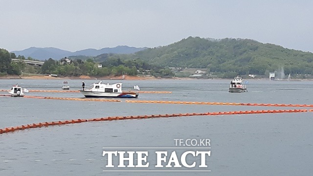 23일 오후 2시30분쯤 인양팀이 사고헬기가 수면으로 떠올 때 항공유 유출을 대비해 오일펜스를 설치하고 있다. / 김영재 기자