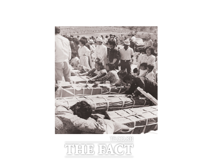 80년 5월 29일 광주 망월동에서 일제히 진행된 129 구의 장례식에서 희생자 시신이 안치된 관을 붙들고 유족들이 오열하고 있다./5.18기념재단 제공