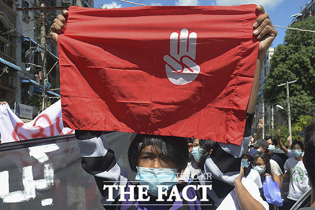 반 쿠데타 시위대가 5월 11일 (현지시간) 미얀마 양곤에서 열린 시위에서 세 손가락 경례를 하는 구호를 들고 있다. /양곤=AP.뉴시스