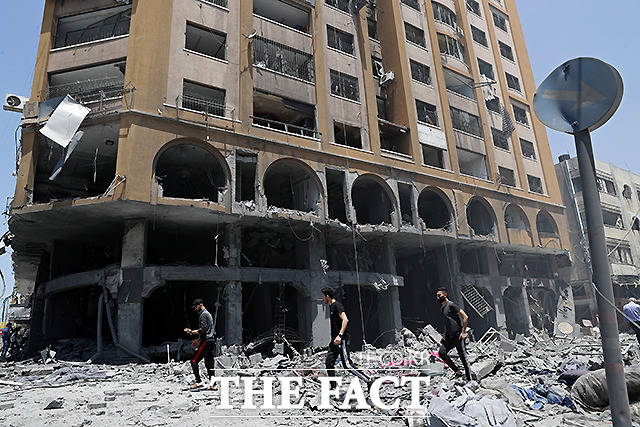 12일 가자지구에서 사람들이 이스라엘군의 공습으로 피해를 입은 건물 잔해를 살펴보고 있다. /AP.뉴시스
