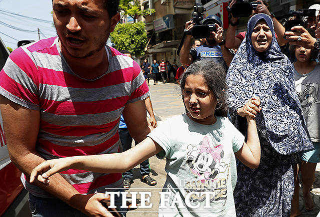 11일 가자지구에서 한 남성이 부상당한 소녀와 여성을 구급차에 태우고 있다. /AP.뉴시스