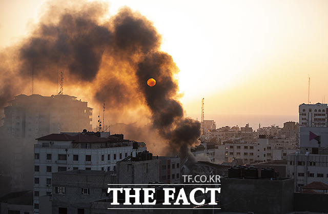 12일(현지시간) 이스라엘의 공습으로 가자지구 내 무너진 건물에서 연기가 보이고 있다. /가자지구=AP.뉴시스