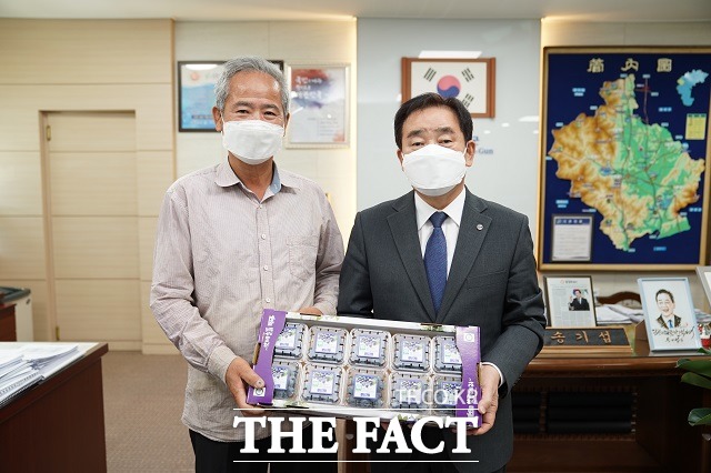 충북 진천 백곡에서 블루베리를 재배하는 이주경씨(왼쪽)가 송기섭 군수와 올해 출하된 제품을 두고 기념촬영을 하고 있다. / 진천군 제공