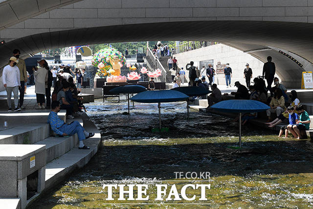 그늘에 앉아 여유로운 시간을 즐기는 시민들.