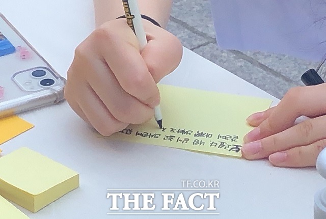 22일 청주 성안길 롯데시네마 앞에서 열린 청주여중생 추모제에서 한 친구가 포스트잇에 추모 글을 적고 있다. / 전유진 기자