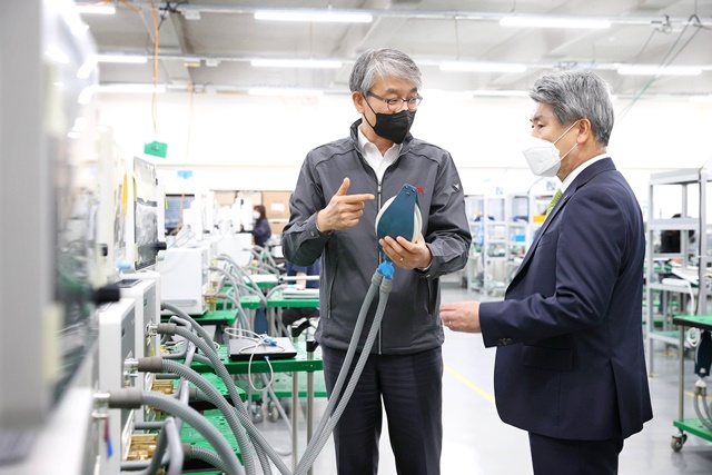 21일 윤종원 기업은행장(오른족)이 경기도 파주에 위치한 인공호흡기 제조 기업 멕아이씨에스를 방문해 김종철 대표(왼쪽)로부터 생산공정에 대해 설명을 듣고 있다. /기업은행 제공