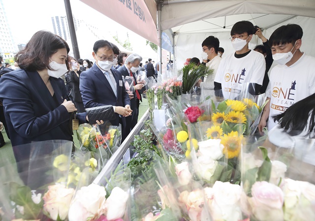 구현모 KT 대표(왼쪽에서 두 번째)가 25일 서울 종로구 KT스퀘어에서 열린 나눠정(情) 나눔장터에서 꽃다발을 구입하고 있다. /KT 제공