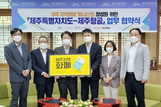 지난 26일 오후 최승현 제주특별자치도 행정부지사(왼쪽에서 세 번째)와 이철행 제주항공 대외협력본부장(왼쪽에서 네 번째)이 제주특별자치도 소통회의실에서 제주항공과 제주특별자치도의 탐나는전 활성화 추진 업무협약을 체결 후 기념촬영을 하고 있다. /제주항공 제공