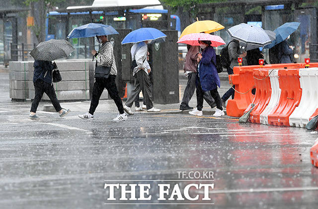수도권에서 시작해 전국에 돌풍·천둥·번개 등을 동반한 비 소식이 예보된 27일 오전 서울 광화문 거리의 직장인들이 우산을 들고 발걸음을 옮기고 있다./임영무 기자