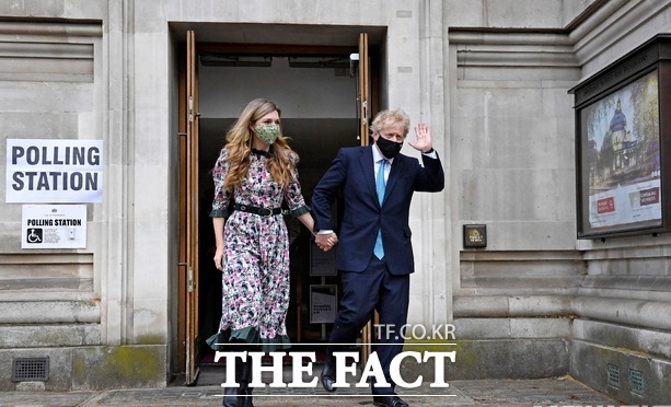 보리스 존슨 영국 총리가 5월 6일(현지시간) 런던의 한 지방선거 투표소에서 약혼자 캐리 시먼즈와 함께 투표를 마치고 나오며 손을 흔들고 있다. /런던=AP.뉴시스