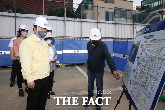 한범덕 청주시장(왼쪽)이 2일 철근 수급문제로 공사가 중단된 모충동 청주시 가족센터 건립현장에서 공사관계자로부터 현황보고를 받고 있다. / 청주시 제공