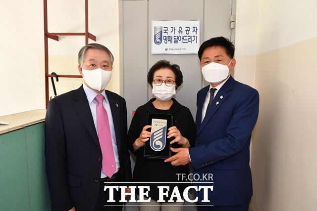 2일 서울여성플라자에서 열린 2021 거버넌스지방정치대상 공모대회에서 코로나 대응 부문 최우수상을 탄 최충진 청주시의회 의장(오른쪽)이 이날 우동교 충북남부보훈지청장(왼쪽)과 함께 월남전에 참전했다가 고엽제 후유증으로 사망한 고(故) 이남열씨의 부인 이순옥(가운데) 대한민국전몰군경미망인회 청주시지회장의 자택에 국가유공자의 집 명패를 달고 기념촬영을 하고 있다. / 청주시의회 제공