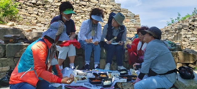 삼년산성을 찾은 여행객들이 준비해온 도시락을 먹고 있다. / 보은군 제공