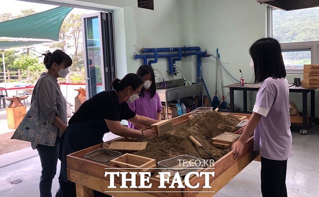 5일 오전 충북 보은 농경문화관을 찾은 모녀가 모래로 틀을 만들어 액체 상태의 금속을 붓는 주조 체험을 하고 있다. / 보은=전유진 기자