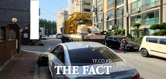 광주 광산구 소촌동 현대 힐스테이트 아파트 신축 공사현장을 오가는 대형 공사 차량이 초등학생 등하교와 어르신들의 보행에 큰 위협을 주고 있는 것으로 나타났다. 사진은 공사현장 크레인 몸체를 실은 화물차량이 주민을 피해가고 있는 모습이 아슬아슬하다./광주=문승용 기자