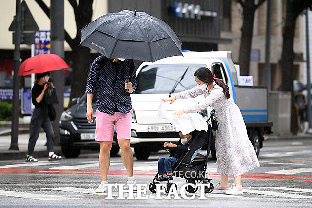 전국이 대체로 흐리고 곳곳에 비 소식이 있는 15일 오전 서울 광화문 일대에서 한 여성이 유모차 안의 아이가 비에 젖지 않게 천을 씌우고 있다. /이새롬 기자